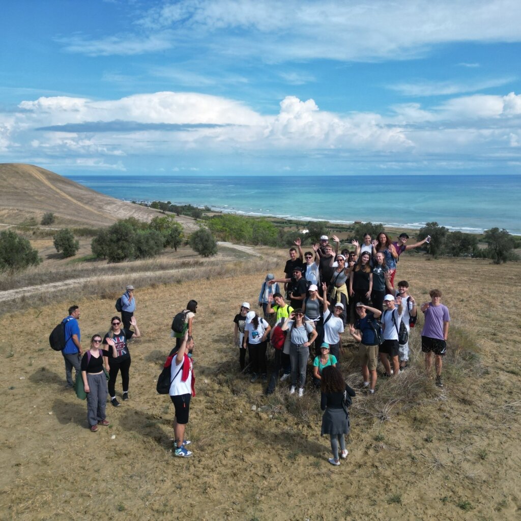 persone che passeggiano su una collina con il mare all'orizzonte